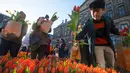 Seorang pria memetik tulip pada Hari Bunga Tulip Nasional di Dam Square, Amsterdam pada 19 Januari 2019. Pengunjung bisa memetik bunga tulip yang terhampar seluas 2.500 meter persegi secara cuma-cuma. (AP/Peter Dejong)