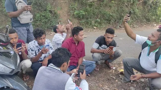 Warga, perangkat desa dan pendamping desa sedang mencari sinyal di daerah yang bisa masuk jaringan internet. (Liputan6.com/ Dionisius Wilibardus)