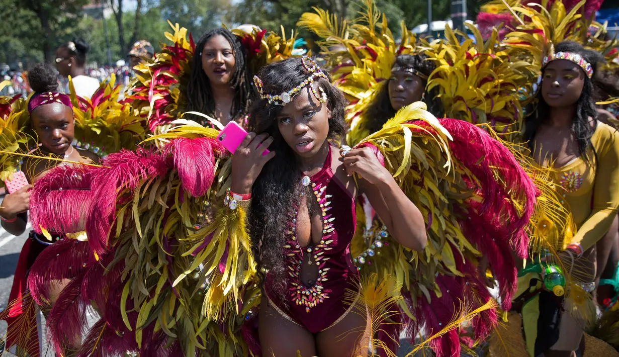 Sejumlah penari mengenakan kostum bulu warna-warni selama Parade West Indian Day di Brooklyn borough, New York, Senin (4/9). Parade tersebut merupakan salah satu perayaan budaya Karibia terbesar di Amerika Serikat. (AP Photo/Kevin Hagen)