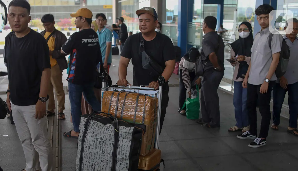 Penumpang membawa barang bawaan mereka menuju bus tujuannya di Terminal Terpadu Pulogebang, Jakarta, Kamis (23/5/2024). (Liputan6.com/Herman Zakharia)
