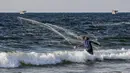Seorang nelayan Palestina melemparkan jala ikan saat menangkap ikan di Laut Mediterania, Rafah, Jalur Gaza, Rabu (2/9/2020). (SAID KHATIB/AFP)