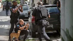Para polisi militer Rio de Janeiro mengambil posisi saat melakukan operasi penggerebekan di daerah kumuh Cidade de Deus di Rio de Janeiro, Brasil (1/2). (AFP Photo/Mauro Pimentel)