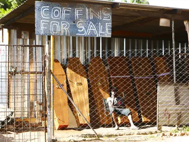 Seorang pekerja perusahaan pembuat peti mati menunggu klien di Harare, Selasa (5/1/2021). Zimbabwe memulai lockdown selama 30 hari dalam upaya untuk mengendalikan lonjakan infeksi COVID-19 yang mengancam petugas kesehatan. (AP Photo/Tsvangirayi Mukwazhi)
