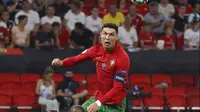 Pemain Portugal Cristiano Ronaldo menyundul bola di atas pemain Prancis Presnel Kimpembe pada pertandingan Grup F Euro 2020 di Puskas Arena, Budapest, Hungaria, Rabu (23/6/2021). Laga berakhir imbang 2-2. (Bernadett Szabo, Pool photo via AP)