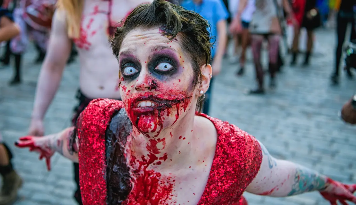 Seorang wanita dengan riasan zombie ikut berpartisipasi dalam parade "Zombie Walk" di Stockholm, Swedia, Sabtu (19/8). Zombie Walk adalah acara yang rutin dilakukan saat musim panas tiba, tepatnya akhir Agustus. (Jonathan NACKSTRAND/AFP)