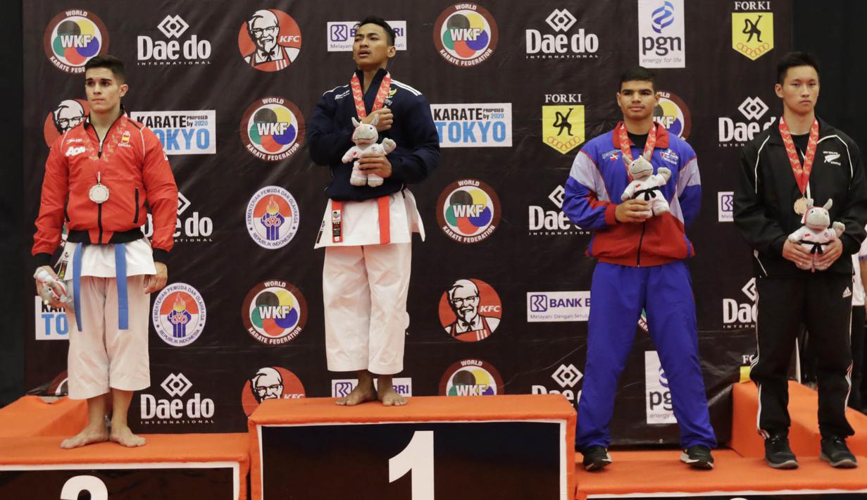 Karateka Indonesia, Ahmad Zigi Zaresta naik podium dan mengumandangkan Indonesia Raya usai meraih juara nomor Junior Kata pada Kejuaraan Dunia Karate Junior, Cadet dan U-21, di ICE, BSD, Tangerang, Kamis (12/11/2015). (Bola.com/Vitalis Yogi Trisna)