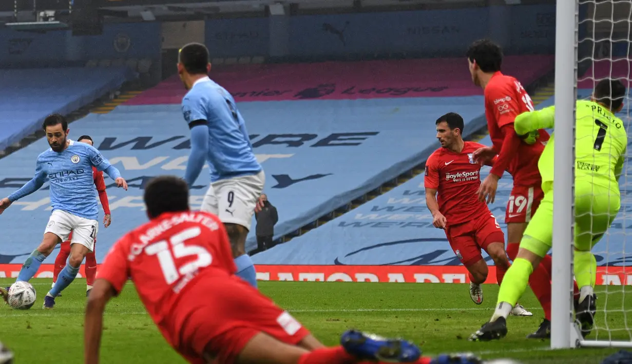Gelandang Manchester City, Bernardo Silva (kiri) melepaskan tendangan yang berbuah gol kedua timnya ke gawang Birmingham City dalam laga babak ke-3 Piala FA 2020/21 di Etihad Stadium, Minggu (10/1/2021). Manchester City menang 3-0 atas Birmingham City. (AFP/Oli Scarff/Pool)