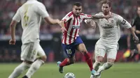 Penyerang Atletico Madrid, Angel Correa (tengah) menggiring bola dari kejaran bek Real Madrid, Sergio Ramos (kanan) selama pertandingan lanjutan La Liga di stadion Wanda Metropolitano, Spanyol (28/9/2019). Madrid dan Atletico bermain imbang 0-0. (AP Photo/Bernat Armangue)