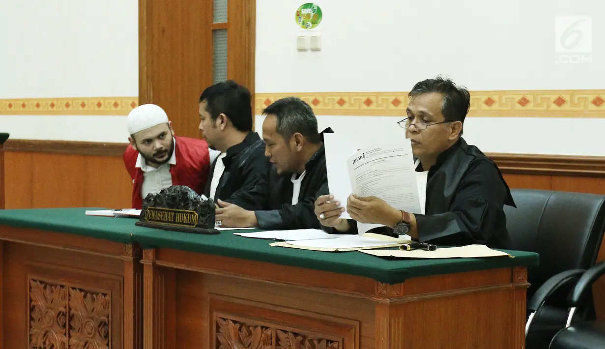 Pedangdut Ridho Rhoma berbincang dengan kuasa hukumnya di Pengadilan Negeri Jakarta Barat, Selasa (4/7). Ridho Rhoma menjalani sidang perdana kasus narkoba dengan agenda mendengarkan pembacaan surat dakwaan dari JPU. (Liputan6.com/Herman Zakharia)