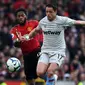 Striker West Ham United, Javier Hernandez berusaha menggiring bola dari kejaran gelandang Manchester United, Fred selama pertandingan lanjutan Liga Inggris di Old Trafford (13/4). MU menang tipis atas West Ham 2-1. (AFP Photo/Paul Ellis)