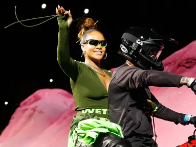Penyanyi Rihanna menyapa penonton saat berada di motor trail membawakan busana koleksi dari Fenty Puma musim semi 2018 selama New York Fashion Week di New York, AS (10/9). (AP Photo / Bebeto Matthews)