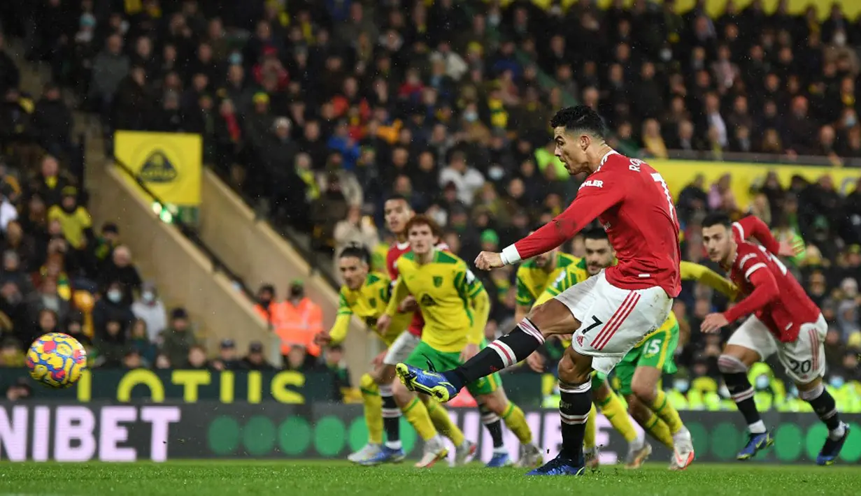 Pemain Manchester United Cristiano Ronaldo mencetak gol ke gawang Norwich City dari titik penalti pada pertandingan sepak bola Liga Inggris di Stadion Carrow Road, Norwich, Inggris, 11 Desember 2021. Manchester United menang 1-0. (Daniel LEAL/AFP)