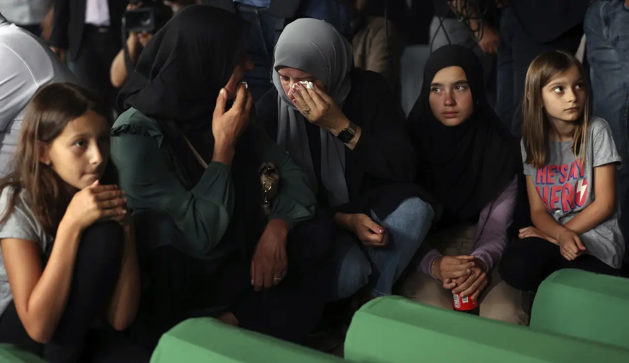 Wanita muslim berdoa dekat peti mati kerabat mereka yang menjadi korban genosida Srebrenica 1995 di Potocari, Bosnia, 8 Juli 2022. Sebanyak 50 jenazah korban genosida Srebrenica yang baru diidentifikasi, satu-satunya genosida yang diakui di Eropa sejak Perang Dunia II, tiba di Memorial Center di Potocari di mana mereka akan dimakamkan pada 11 Juli. (AP Photo/Armin Durgut)