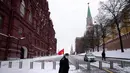 Pendukung komunis tua membawa bendera merah bekas Uni Soviet akan meletakkan bunga di makam pemimpin Soviet Josef Stalin pada peringatan 142 tahun kelahirannya di dekat Tembok Kremlin di Lapangan Merah dengan makam Lenin di kanan di Moskow, Rusia (21/12/2021). (AP Photo/Alexander Zemlanichenko)