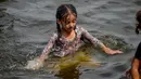Seorang anak perempuan mendinginkan diri ke perairan Laut Arab saat musim panas di Karachi pada 5 Juli 2020. Warga Pakistan menghabiskan hari yang cerah dengan berenang di tengah pandemi virus corona. (Photo by Rizwan TABASSUM / AFP)