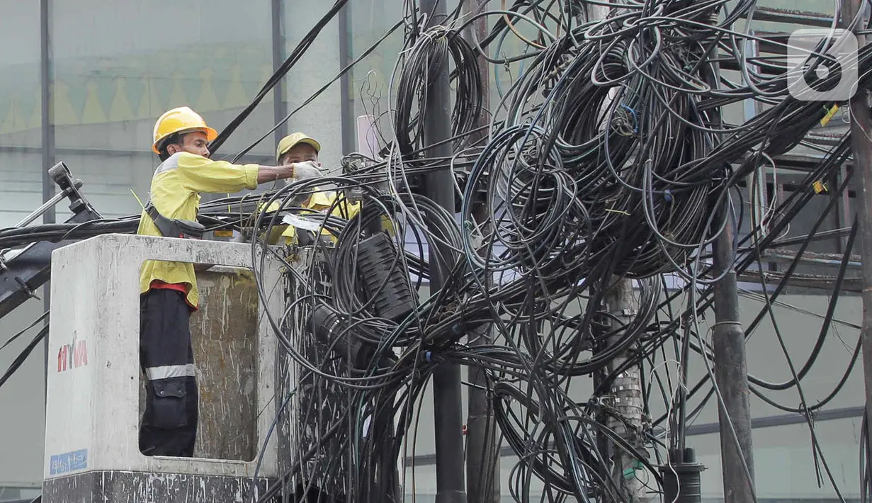 Petugas Dinas Bina Marga DKI Jakarta melakukan penataan kabel utilitas di kawasan Kapten Tendean, Jakarta, Kamis (14/9/2023). (Liputan6.com/Herman Zakharia)