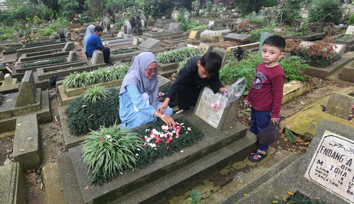 Warga berziarah di makam keluarganya di Tempat Pemakaman Umum (TPU) Dreded, Bogor, Jawa Barat, Minggu (15/2/2026). Jelang bulan suci Ramadan, sejumlah Tempat Pemakaman Umum (TPU) mengalami lonjakan peziarah. (merdeka.com/Arie Basuki)