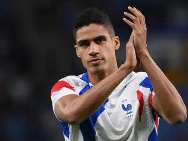 Bek Prancis, Raphael Varane memberi tepuk tangan kepada pendukung menjelang pertandingan melawan Australia pada Grup D Piala Dunia Qatar 2022 di Stadion Al-Janoub di Al-Wakrah, selatan Doha pada 22 November 2022. Varane mengumumkan pensiun dari sepak bola internasional setelah 10 tahun membela tim nasional Prancis pada usia 29 tahun. (AFP/FRANCK FIFE)