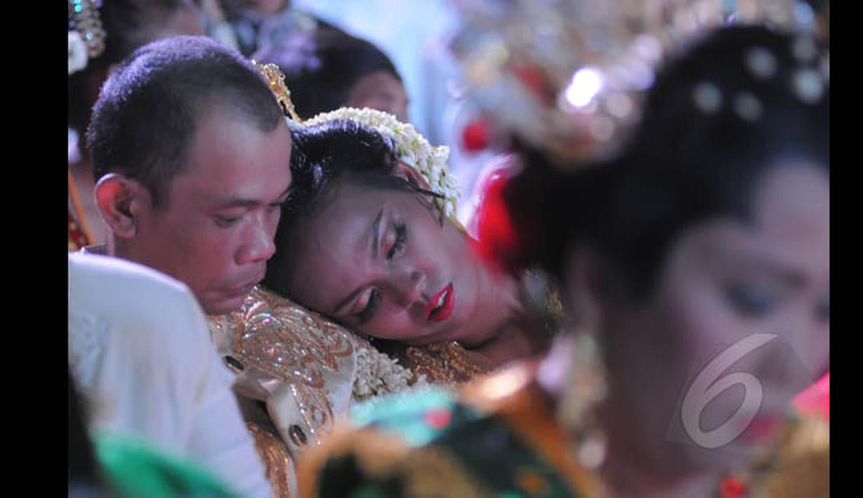Seorang pengantin tampak terlelap saat menunggu giliran prosesi pernikahan massal di Istora Senayan, Jakarta, Rabu (28/1/2015). (Liputan6.com/Herman Zakharia)