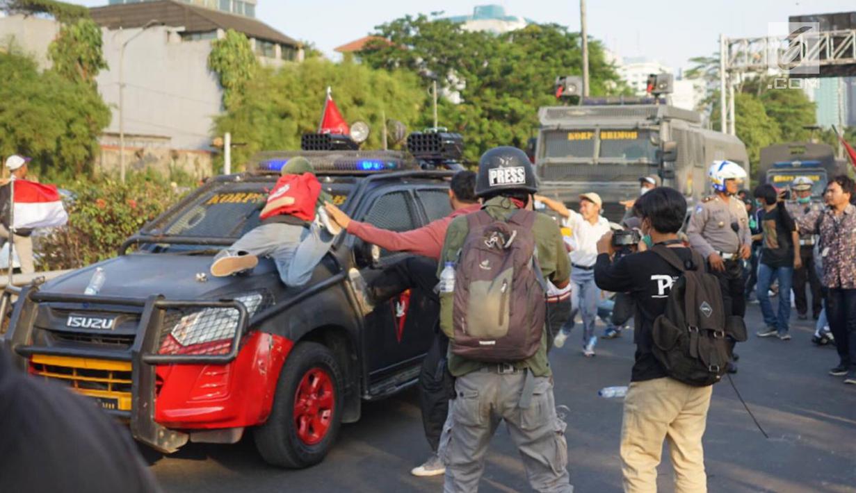 Massa pelajar menyerang kendaraan milik kepolisian yang melintas saat aksi unjuk rasa  di sekitar kawasan DPR RI, Jakarta, Senin (30/9/2019). Sempat terjadi kericuhan akibat peristiwa tersebut hingga menyebabkan jalan tol ditutup. (Liputan6.com/Immanuel Antonius)