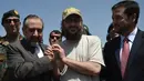 Putra mantan PM Pakistan Yusuf Raza Gilani, Ali Haider Gilani berjabat tangan dengan Dubes Pakistan untuk Afghanistan, Syed Abrar Hussain saat tiba di Kabul, Rabu (11/5). Ali Haider berhasil dibebaskan setelah diculik sejak 2013 lalu. (Wakil KOHSAR/AFP)
