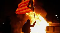 Massa mengibarkan bendera saat demonstrasi di luar Stadion Camp Nou, Spanyol, Rabu (18/12/2019) atau Kamis dini hari WIB. (Pau Barrena / AFP)