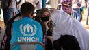 Aktris Angelina Jolie, utusan khusus PBB untuk UNHCR, berbincang dengan pengungsi Mali di kamp Goudebou, utara Burkina Faso, 20 Juni 2021. Jolie mengunjungi kamp pengungsi yang menampung ribuan warga Mali yang menyelamatkan diri dari kekerasan militan di kawasan itu. (OLYMPIA DE MAISMONT/AFP)