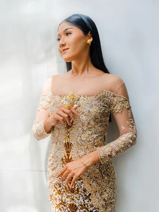 Kebaya modern juga terlihat sangat cantik ketika dikenakan Erina Gudono. Kebaya brokat bernuansa keemasan tampak membalut tubuh Erina dengan sempurna, ia pasangkan kebaya ini dengan kain batik yang juga bernuansa cokelat kekuningan, dan tatanan rambut lurus yang dibiarkan tergerai.
