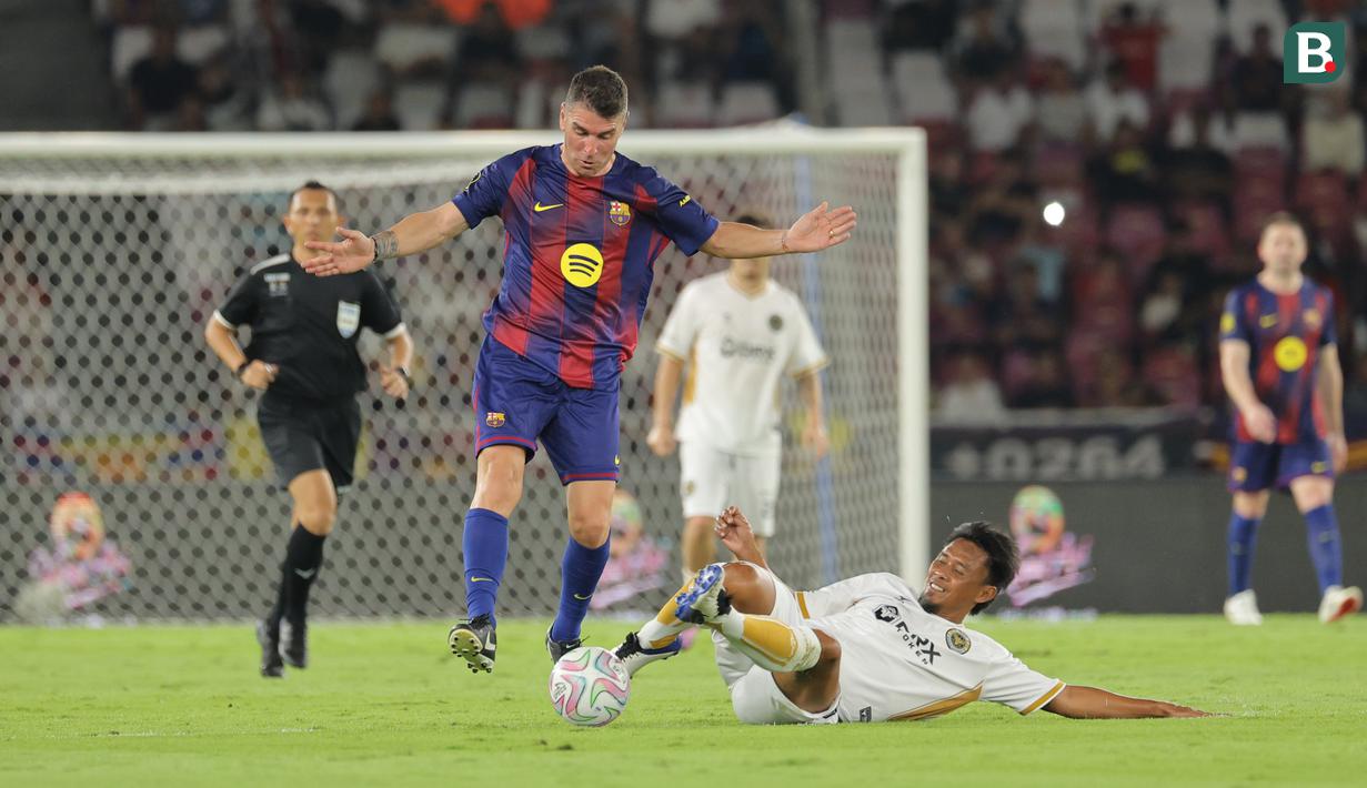 Pemain Barcelona Legends, Javier Soriano berebut bola dengan pemain DRX World Legends, Maman Abdurrahman dalam laga Clash of Legends di Stadion Utama Gelora Bung Karno (SUGBK), Senayan, Jakarta, Sabtu (18/04/2026). (Bola.com/Bagaskara Lazuardi)