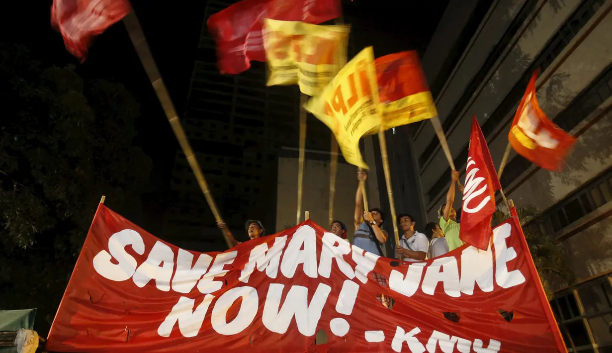 Aktivis mengibarkan bendera organisasi mereka setelah mendengar pemerintah Indonesia menunda pelaksanaan eksekusi hukuman mati terhadap Mary Jane, di depan Kedutaan Indonesia di Filipina, Rabu (29/4/2015). (REUTERS/Erik De Castro)