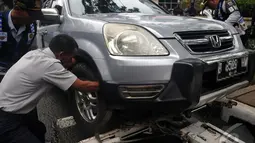Di awal tahun 2015 Dinas Perhubungan DKI Jakarta terus melakukan sweeping agar pemilik kendaraan jera dengan pengangkutan dan pengempesan kendaraanya yang di parkir sembarangan, Jakarta, Senin (12/1/2015). (Liputan6.com/Johan Tallo)