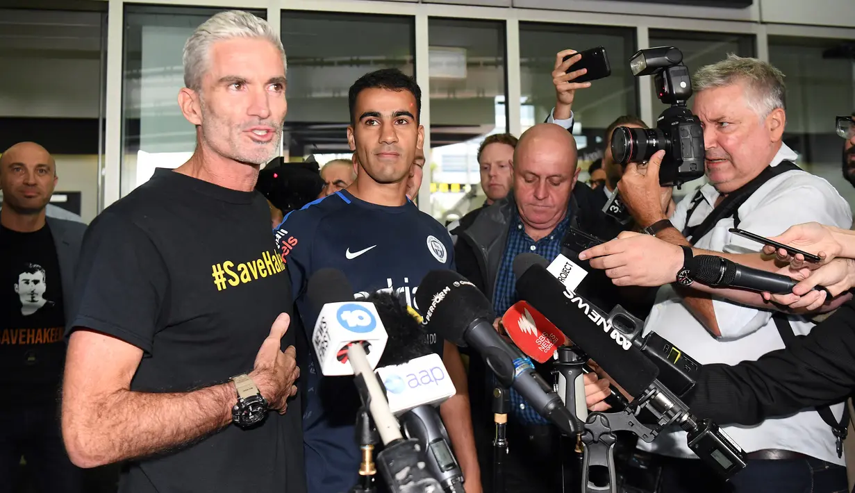 Mantan pemain Socceroo Craig Foster mendampingi pemain sepakbola dan pengungsi Australia, Hakeem al-Araibi memberikan ketengan pers setibanya mereka di bandara Melbourne, Selasa (12/2).  (WILLIAM WEST/AFP)