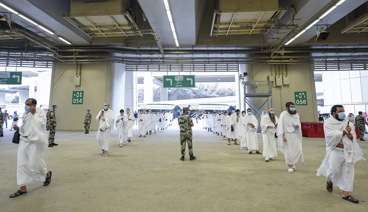 Jemaah haji antre dengan menerapkan jaga jarak aman untuk menghindari penularan COVID-19 saat akan melangsungkan lontar jumrah di Mina, Arab Saudi, Jumat (31/7/2020). Ritual melempar batu ke pilar ini menjadi simbol merajam setan. (Saudi Ministry of Media via AP)