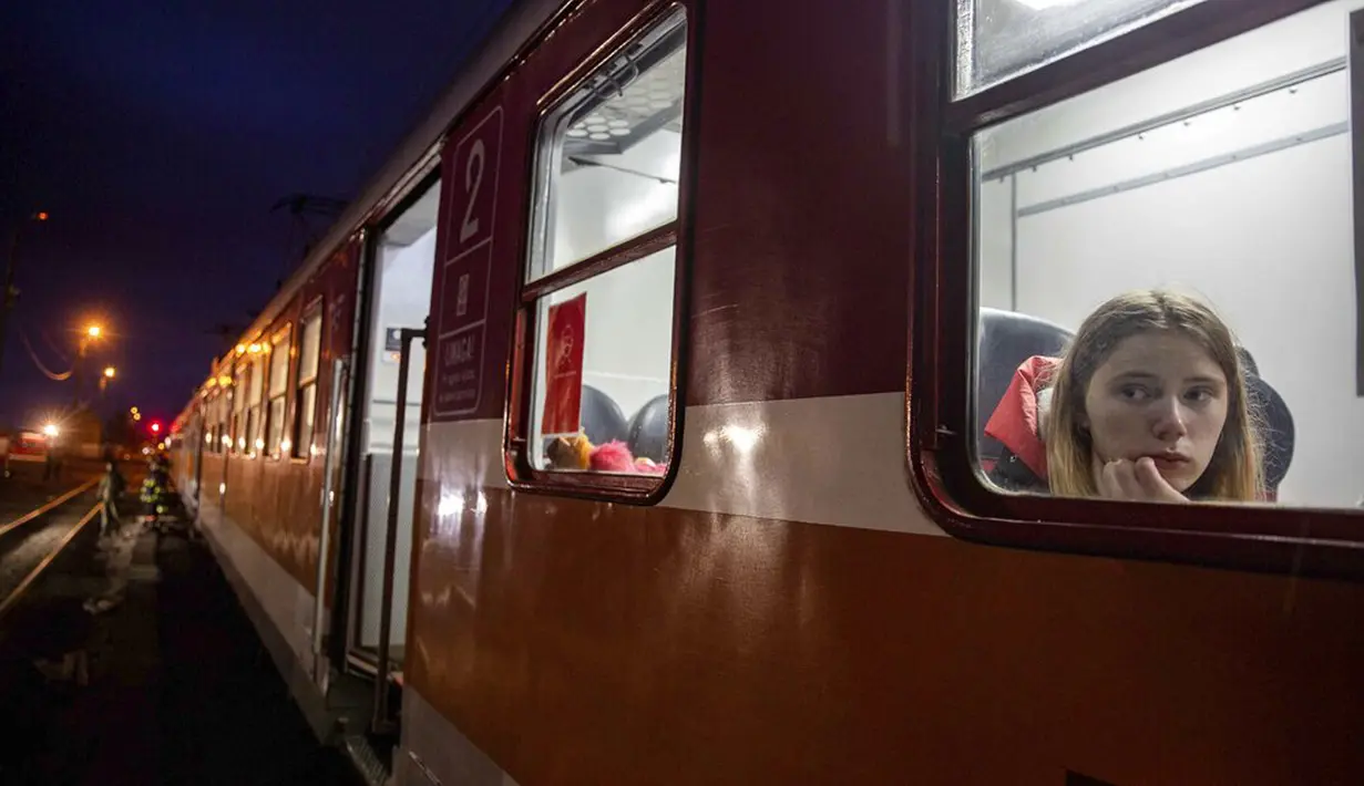 Seorang wanita melihat keluar dari kereta menuju Krakow setelah melarikan diri dari Ukraina di stasiun kereta api di persimpangan perbatasan di Medyka, Polandia, 8 Maret 2022. PBB mengatakan, serangan gencar Rusia telah memaksa lebih dari 2 juta orang meninggalkan Ukraina. (AP Photo/Visar Kryeziu)