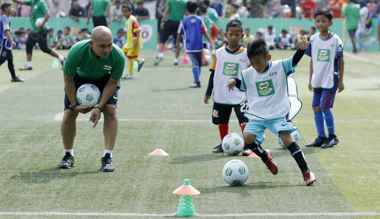 Seorang anak menggiring bola saat mengikuti MILO Football Clinic Day di Lapangan Simprug, Jakarta, Sabtu (16/12/2017). Sebanyak 500 anak mendapatkan pelatihan dasar teknik sepak bola dari pelatih berpengalaman. (Bola.com/M Iqbal Ichsan)
