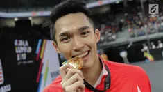 Pebulu tangkis putra Indonesia Jonatan Christie mengigit medali emas merayakan kemenangan pada final tunggal putra SEA Games 2017 melawan Khosit Phetpradab dari Thailand di Axiata Arena, Malaysia, Selasa (29/8). (Liputan6.com/Faizal Fanani)