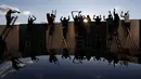 Penggemar, berdiri di tangga dari belakang pagar, merayakan gol saat mereka menonton pertandingan divisi pertama Ceko antara Bohemians Prague dan Zlin di Praha (4/10/2020). Para penggemar mencari cara inovatif untuk menonton pertandingan selama pandemi virus corona. (AP Photo/Petr David Josek)
