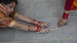 Seorang pemuja Hindu Nepal bergerak sambil berbaring sujud, sebagai bagian dari ritual, selama festival Chhath Puja di Kathmandu, Nepal, Rabu (10/11/2021). Selama Chhath, sebuah festival Hindu kuno, ritual dilakukan untuk terima kasih kepada Dewa Matahari. (AP Photo/Niranjan Shrestha)