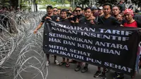Pengemudi online membentangkan spanduk saat menggelar aksi di kantor pusat Grab, Jakarta, Senin (29/10). Mereka menuntut penentuan tarif dan skema yang manusiawi, serta monopoli dan diskriminasi order (order prioritas). (Liputan6.com/Faizal Fanani)