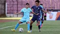 Pemain Madura United, Esteban Vizcarra (kiri) menguasai bola dibayangi pemain Arema FC, Renshi Yamaguchi dalam laga pekan ke-16 BRI Liga 1 2022/2023 di Stadion Sultan Agung, Yogyakarta, Selasa (20/12/2022) sore WIB. (Bola.com/Ikhwan Yanuar)