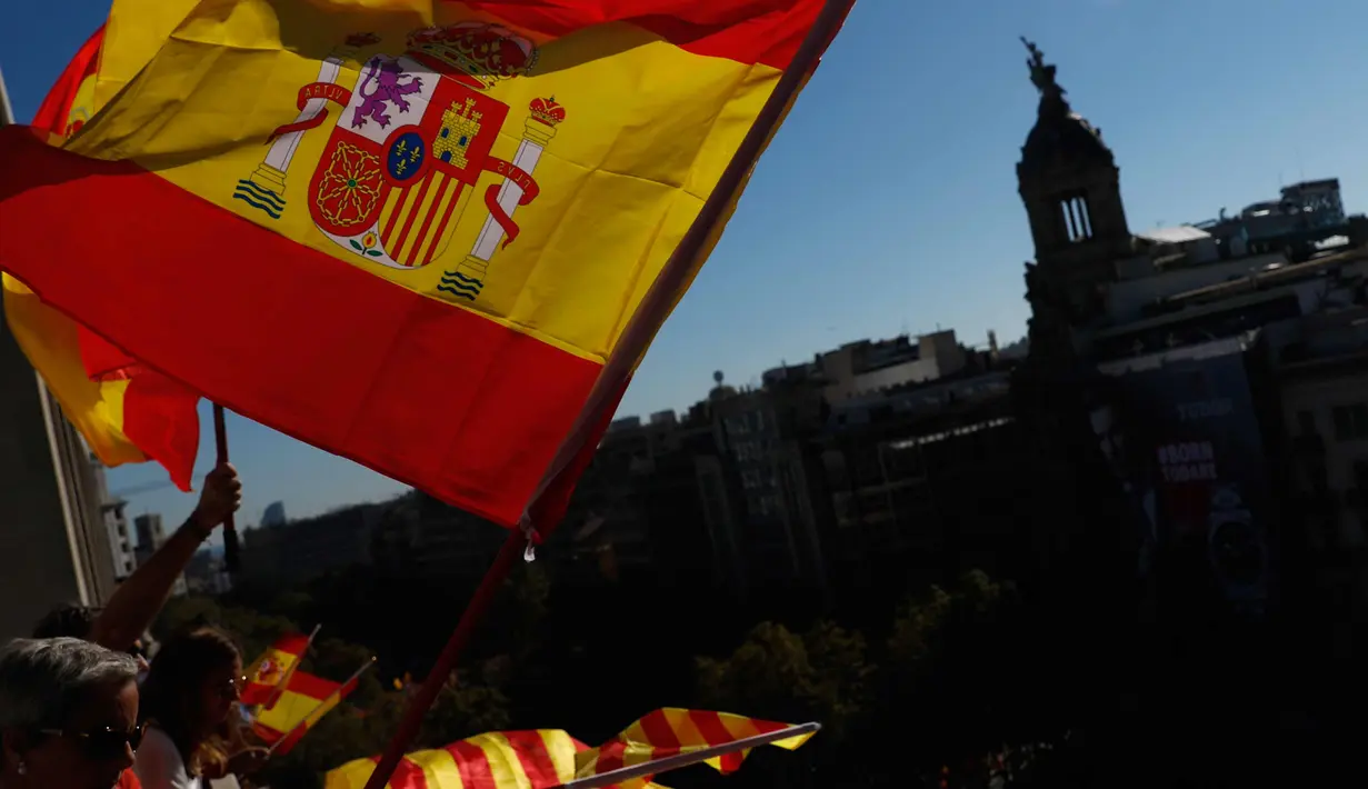 Warga mengibarkan bendera Spanyol dan Catalonia selama demonstrasi massal melawan deklarasi kemerdekaan Catalonia, di Barcelona, Spanyol, (29/10). Mereka menyerukan persatuan dan menolak deklarasi kemerdekaan Catalan. (AP Photo/Gonzalo Arroyo)