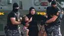 Polisi anti huru-hara mengevakuasi imigran wanita dan anaknya dari bentrokan yang terjadi antara polisi dengan imigran yang berusaha menerobos pintu perbatasan Serbia dan Hungaria di Roszke, Rabu (16/9/2015). (REUTERS/Dado Ruvic)