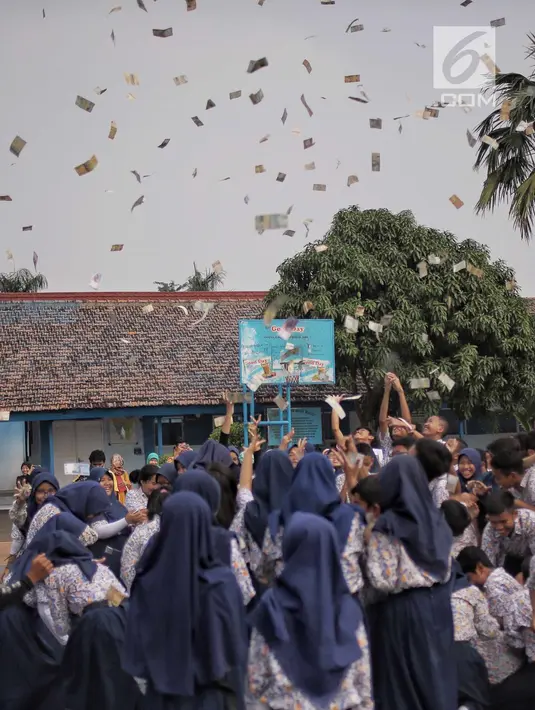 Para murid saling berebut hujan uang di lapangan SMP Angkasa Halim Perdana Kusuma, Jakarta, Kamis (7/6). Hujan uang ini dalam rangka pre-launching buku milik motivator bisnis Tung Desem Waringin berjudul "LIFE REVOLUTION." (Liputan6.com/Faizal Fanani)