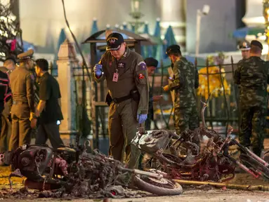 Sejumlah petugas melakukan penyelidikan di lokasi meledaknya bom motor di luar Kuil Erawan di pusat kota Bangkok, Thailand, Senin (17/8/2015). Bom motor tersebut diketahui telah menewaskan sekitar 27 warga. (REUTERS/Athit Perawongmetha)