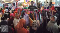 Sejumlah pembeli melihat-lihat baju di Pasar Tanah Abang, Jakarta, Kamis (2/7/2015). Memasuki pertengahan Ramadan pedagang mengaku penjualan baju muslim meningkat dari bulan-bulan sebelumnya. (Liputan6.com/Yoppy Renato)