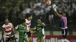 Kiper Madura United, Erry Prasetyo (kanan), mengamankan bola serangan PS TNI dalam laga Torabika Soccer Championship presented by IM3 Ooredoo di Stadion Siliwangi, Bandung, Minggu (1/5/2016). (Bola.com/Vitalis Yogi Trisna)