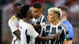Pemain Real Madrid, Vinicius Jr (kiri) melakukan protes terhadap pemain MU, Lisandro Martinez (kanan), dalam pertandingan pramusim Soccer Champions Tour 2023 yang berlangsung di NRG Stadium, Houston, Kamis (27/7/23). Protes tersebut dilakukan karena Martinez melakukan pelanggaran keras berupa tekel dengan kedua kakinya terhadap Jude Bellingham di menit ke-42. (AFP/Getty Images/Tim Warner)