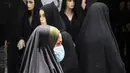 Seorang wanita berjalan melewati pasar pakaian di Kota Basra, Irak, Kamis (21/5/2020). Jelang Idul Fitri, pemerintah Irak melonggarkan lockdown karena pandemi virus corona COVID-19. (Hussein FALEH/AFP)