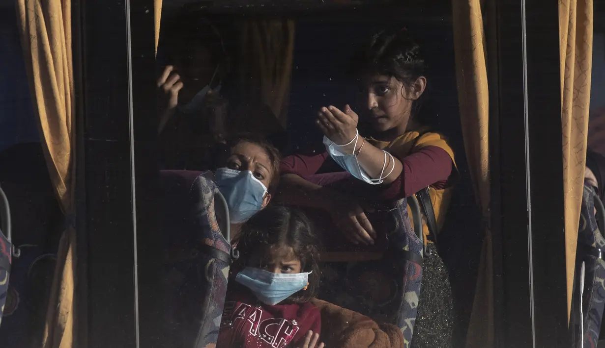 Pengungsi dan migran berangkat dengan bus setelah kedatangan mereka di pelabuhan Lavrio, sekitar 75 kilometer (48miles) selatan Athena (29/9/2020). Pemindahan sebagai bagian dari upaya untuk memperbaiki kondisi di kamp pulau yang penuh sesak. (AP Photo/Petros Giannakouris)
