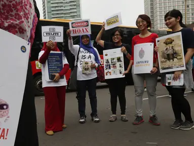 Masyarakat Anti Fitnah Indonesia (Mafindo) menunjukan poster di hari bebas kendaraan bermotor di kawasan Thamrin, Jakarta, Minggu (22/1). Aksi tersebut digelar untuk menghimbau masyarakat terkait berita hoax yang marak beredar. (Liputan6.com/JohanTallo)